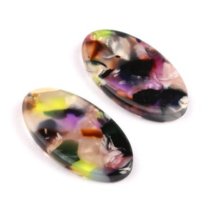 May include: Two oval-shaped resin earrings with a colorful abstract pattern in shades of black, white, pink, purple, green, and yellow.
