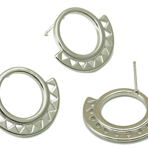 May include: A pair of silver earrings with a circular design and a triangular pattern around the edge.