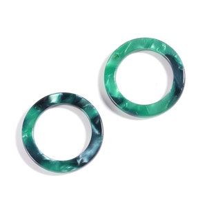 May include: Two green and blue marbled plastic rings. The rings are thick and have a smooth finish.