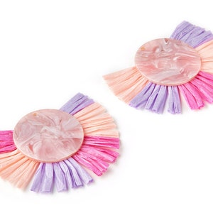 May include: A pair of pink, purple and peach tassel earrings with a round, marbled pink resin centrepiece.