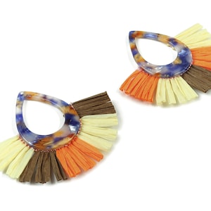 May include: A pair of teardrop-shaped earrings with a multi-coloured marbled design and a fringe of brown, orange, and yellow fabric.