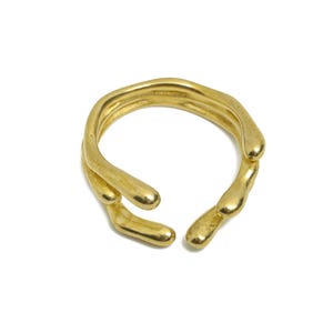 May include: A gold ring with a unique, organic design. The ring is made of multiple intertwined bands that create a textured, flowing look.