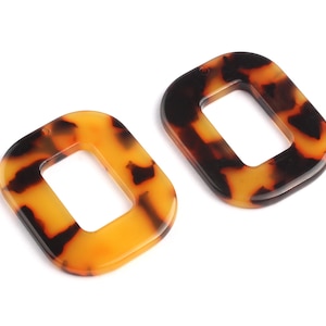 May include: Two brown and orange tortoise shell patterned resin earrings with a square shape and a hole in the center.
