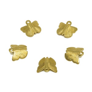 May include: Five gold-colored metal butterfly charms with a loop for attaching to a necklace, bracelet, or other jewelry.
