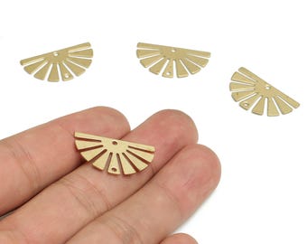May include: Gold-coloured, half-circle metal charms with a sunburst design. The charms have a small hole at the top for stringing. Several charms are visible, with one held in a hand.