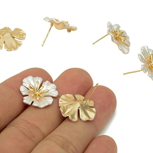 Può includere: Orecchini a bottone floreali con un design bicolore. Gli orecchini hanno una forma a fiore con petali argentati e un centro dorato. I perni degli orecchini sono dorati.