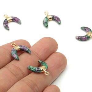 May include: Crescent-shaped gemstone charms with gold-coloured metal accents. The charms feature a mix of green and purple hues. These jewellery components are ideal for crafting earrings, necklaces, or bracelets.