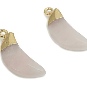 Può includere: Due ciondoli a forma di mezzaluna di colore rosa pallido. La parte superiore di ogni ciondolo è rifinita con un anello in metallo dorato e un accento in metallo dorato. I ciondoli sono lisci e lucidi, ideali per la creazione di gioielli.