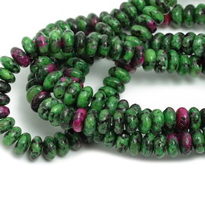 May include: A strand of green and pink gemstone beads. The beads are round and have a speckled pattern.