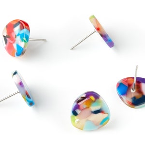 Puede incluir: Cuatro pares de pendientes coloridos con patrones abstractos. Cada pendiente tiene una varilla plateada.