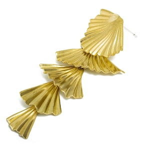 May include: Gold tone earrings with a cascading fan design. The earrings are made of multiple layers of metal that are shaped like fans. The earrings are long and dangle.