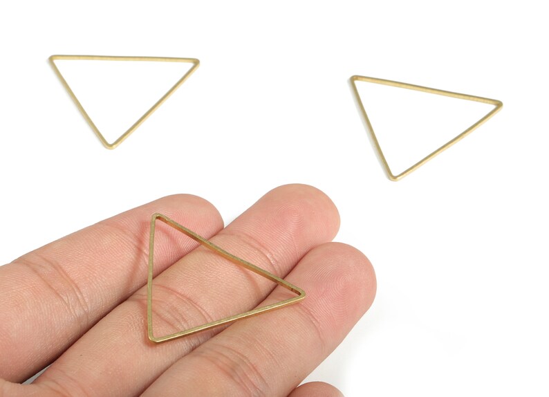 May include: Three gold triangle shaped metal hoops. The hoops are approximately 5 cm in diameter.