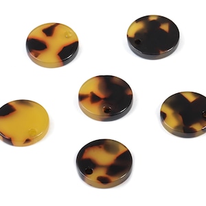 May include: Six round, brown and yellow patterned, plastic discs with a hole in the centre.