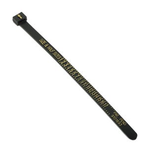 May include: Black ring sizer with gold text indicating sizes from 2 to 17, including half sizes. The text "SIZE & HALF SIZES" is printed on the sizer. The sizer also has the text "PAT. PEND 9101693".