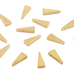 May include: A collection of 14 gold triangle shaped metal charms with a hole at the top. The charms are scattered on a white background.