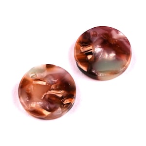 May include: Two round, brown and white patterned resin buttons with a hole in the center.