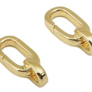 May include: Two gold-toned metal oval-shaped clasps with a spring-loaded closure. The clasps are designed to be used for attaching jewellery or other items.