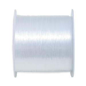 Peut inclure: Une bobine de fil élastique transparent, enroulée sur une bobine en plastique blanche.