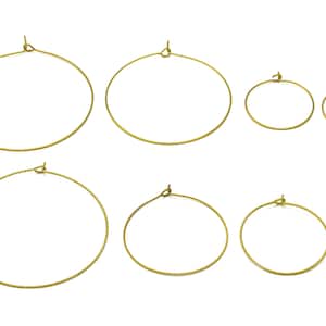 May include: Set of six gold hoop earrings in various sizes. The hoops are made of metal and have a smooth finish.