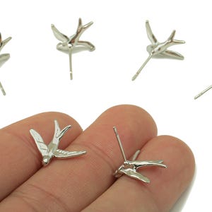 Pendiente de plata con forma de pájaro volador - Pendiente de latón con forma de golondrina - Poste para pendiente con forma de animal - Latón chapado en oro blanco auténtico de 18 quilates - 16,6 x 14,5 x 1,9 mm - RGP5915S