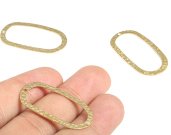 Può includere: Tre elementi di gioielleria ovali dorati con finitura martellata. Uno è tenuto in mano, mentre gli altri due sono posizionati su sfondo bianco. Ognuno ha un piccolo foro per il fissaggio.