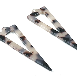 May include: Two white and brown tortoiseshell triangle shaped earrings with a hole at the top for hanging.