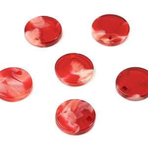 May include: Six red and white marbled round plastic beads with a hole in the center.