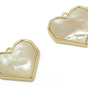 May include: Two gold-toned heart-shaped charms with a white mother-of-pearl inlay.