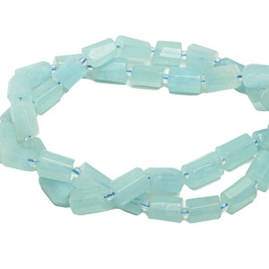 May include: A strand of light blue aquamarine beads, each bead is faceted and has a rectangular shape.