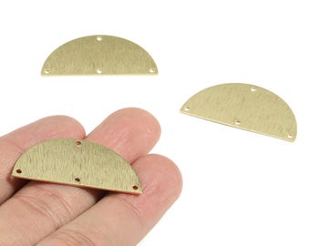 May include: Three brass-colored, half-circle metal jewelry components with a textured finish. Each piece has three small holes for attaching to other components. One piece is held in a hand.