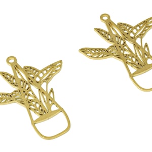 Puede incluir: Dos abalorios de metal dorado en forma de plantas en maceta con intrincados diseños de hojas. Los abalorios tienen un bucle en la parte superior para sujetarlos a joyas u otras manualidades.