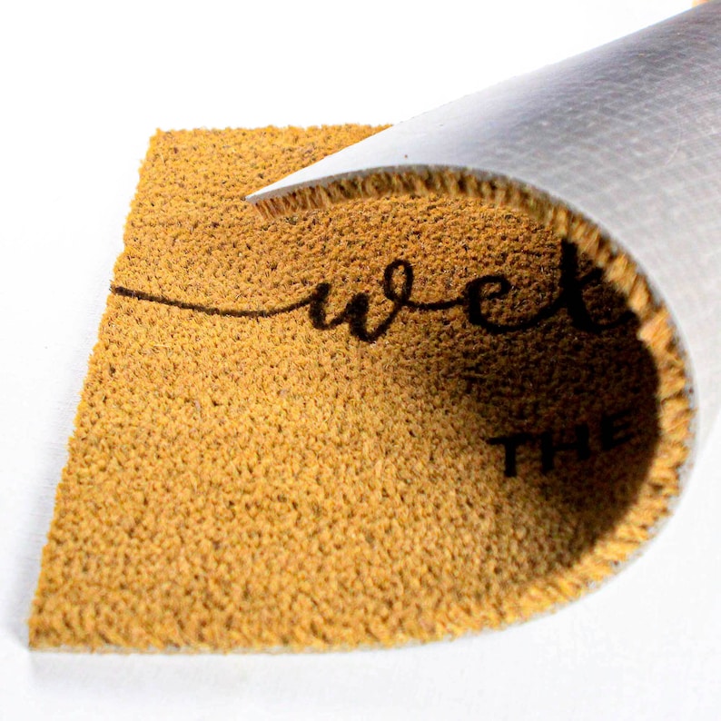May include: A brown coir doormat with the text "Welcome to the" printed in black.