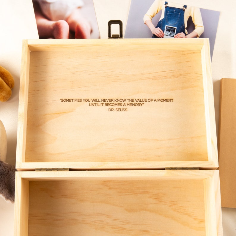May include: A wooden box with a hinged lid, the inside of the box is lined with wood and has an engraved quote: "Sometimes you will never know the value of a moment until it becomes a memory" - Dr. Seuss.
