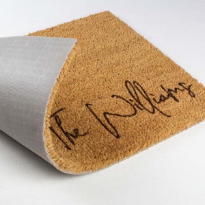May include: A brown coir doormat with the text "The Williams" in black cursive lettering.