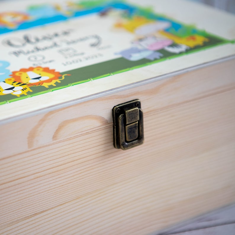 May include: A wooden keepsake box with a brass latch. The lid features a colorful illustration of jungle animals and the text "Olivia Michael Henry 10.11.2021".