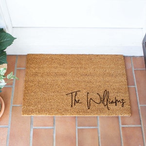 May include: A brown coir doormat with the text "The Williams" in black cursive lettering.