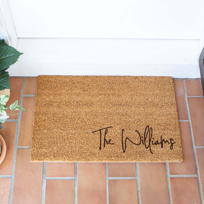 May include: A brown coir doormat with the text "The Williams" in black cursive lettering.