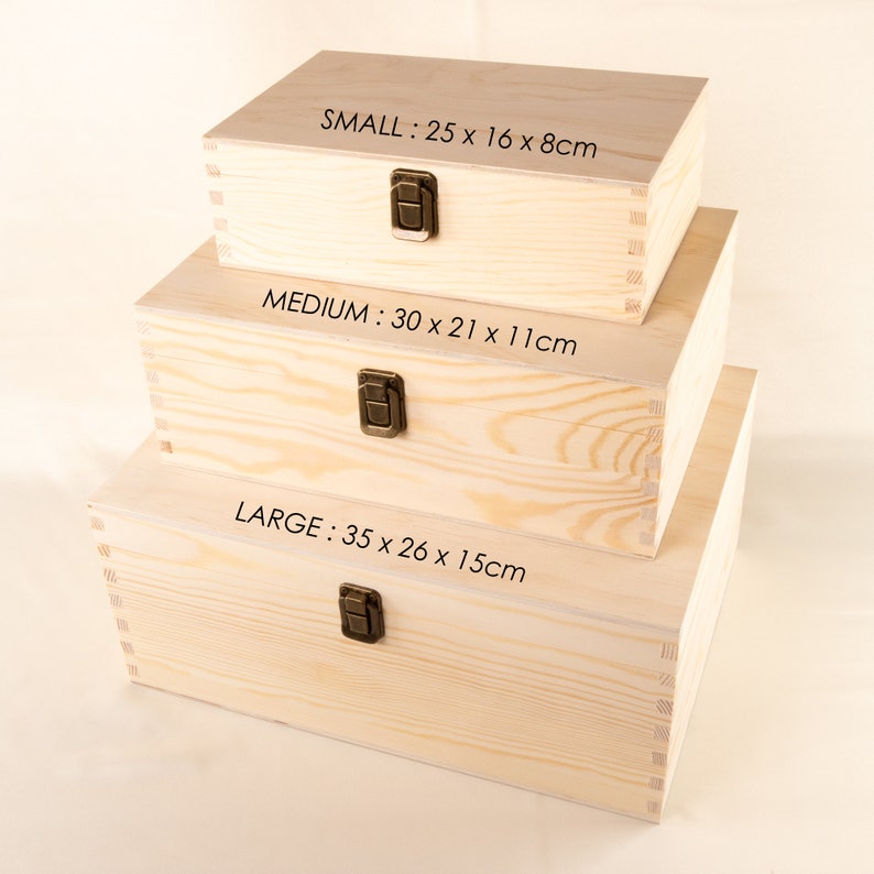 May include: Three wooden boxes stacked on top of each other. The boxes are all made of natural wood and have a light brown color. The top box is labeled "SMALL: 25 x 16 x 8cm", the middle box is labeled "MEDIUM: 30 x 21 x 11cm", and the bottom box is labeled "LARGE: 35 x 26 x 15cm".
