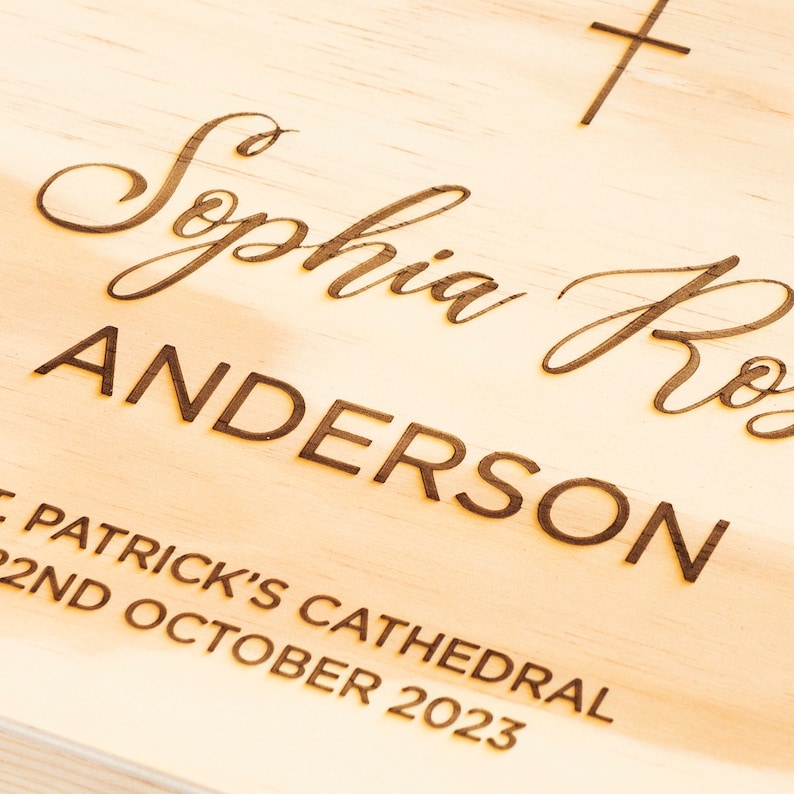 May include: A wooden plaque with the text "Sophia Rose Anderson", "St. Patrick's Cathedral", and "2nd October 2023" engraved on it. A small cross is engraved in the top right corner.