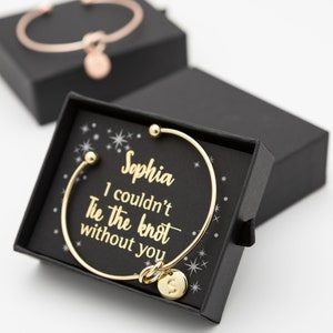 Personalised bangle gift in a gift box with a small card says 'Sophia I couldn't tie the knot without you' in gold foil