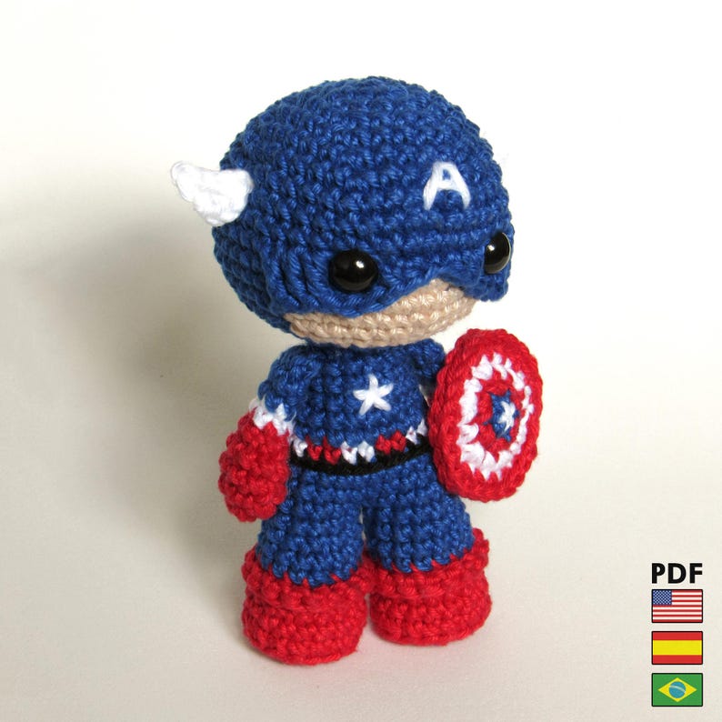 May include: A handmade Captain America amigurumi doll. The doll is crocheted in blue, red, and white yarn, with a shield and the letter "A" on the head. The doll is approximately 5 inches tall.