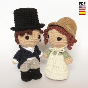 May include: Two crocheted dolls, a man and a woman, in period costume. The man wears a black top hat, navy jacket, and tan trousers. The woman has a bonnet, green top, and cream dress. The dolls are handmade.