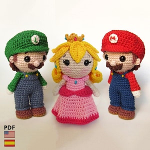 May include: Three handmade crochet figures of Mario, Luigi, and Princess Peach. Mario wears a red hat with a white circle, blue overalls, and a brown mustache. Luigi has a green hat with a white "L", blue overalls, and a brown mustache. Princess Peach wears a pink dress and a gold crown.