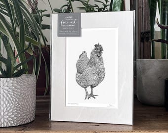 May include: A framed fine art giclée print of a detailed hen illustration, signed by the artist. The black and white artwork is displayed in a white mat and frame, with text that reads "Limited Edition Fine Art". The print is displayed on a wooden surface.