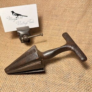 May include: Antique cast iron cone shaped tool with a T-shaped handle. The tool is used for shaping wood.