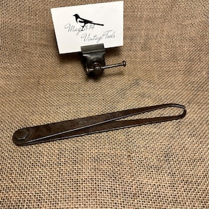 May include: A vintage metal caliper tool with a hexagonal head on one end and a pointed tip on the other. The tool is rusty and has a worn finish.