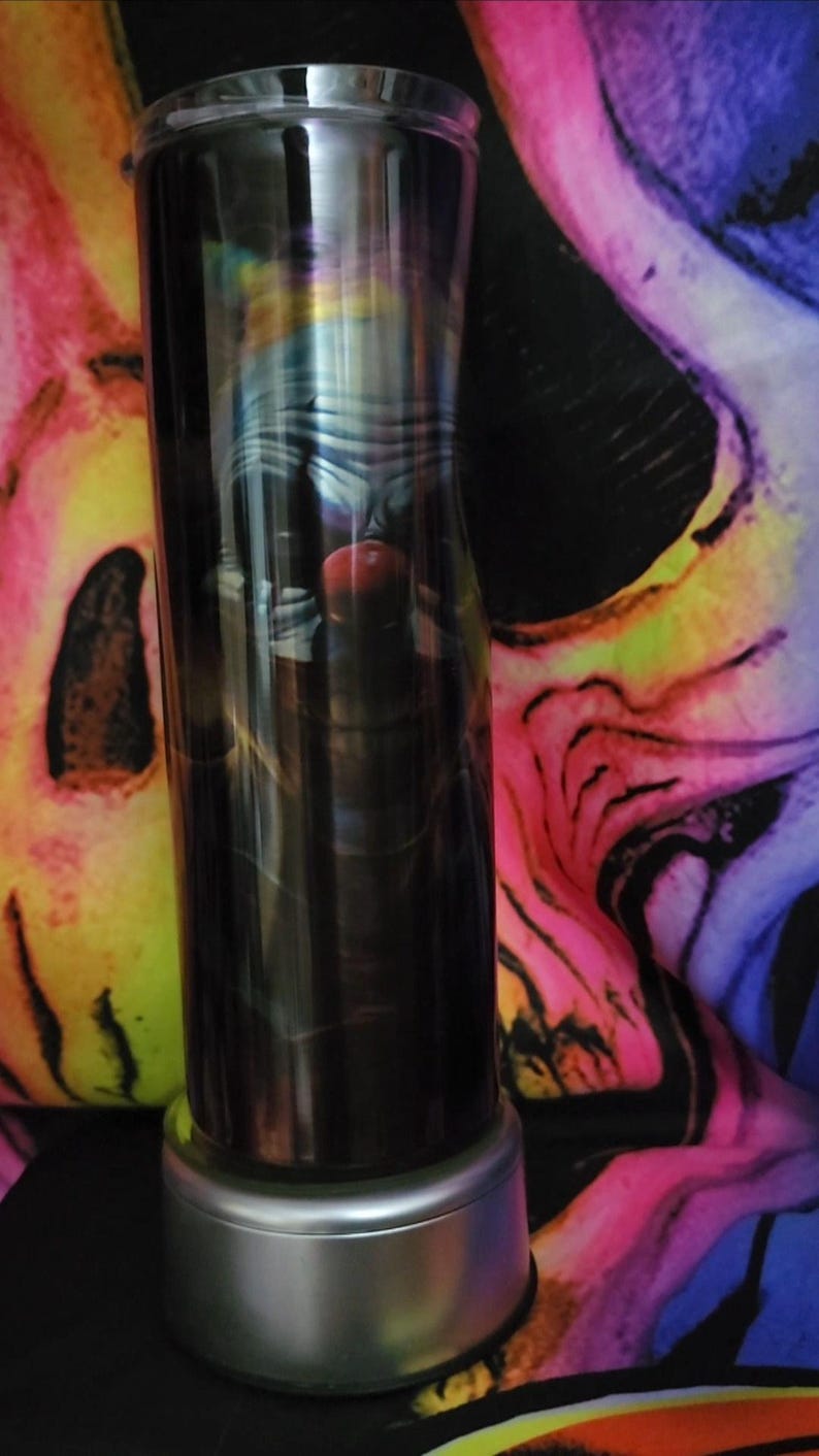 May include: A stainless steel tumbler with a black and white image of a clown with a red nose. The tumbler has a silver base.