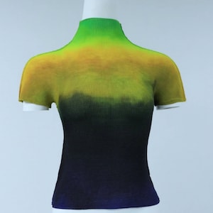 May include: A short-sleeved, green, yellow, and black ombre knit shirt with a mock neck.