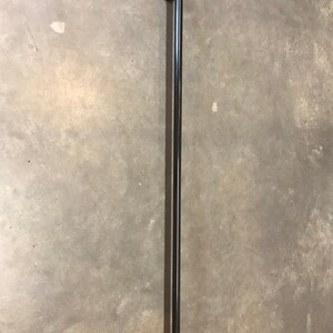 May include: Black metal handrail with two flanges, mounted to a wall.
