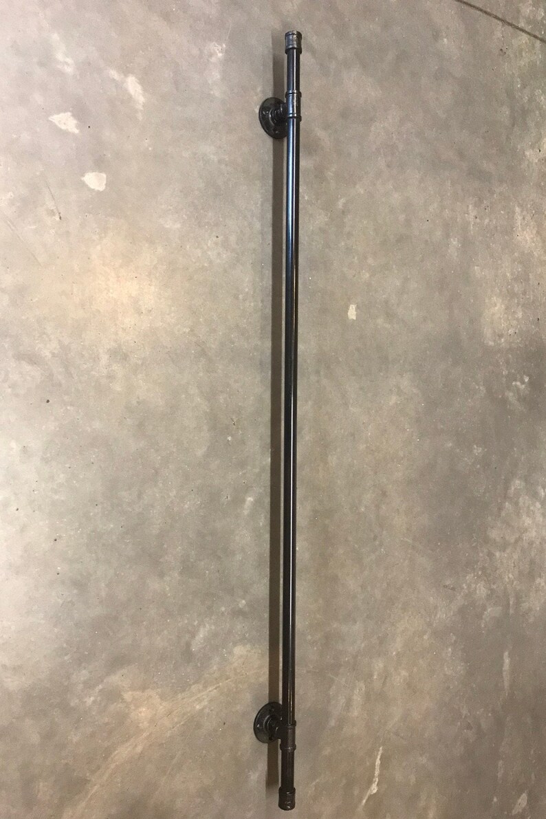 May include: Black metal handrail with two flanges, mounted to a wall.
